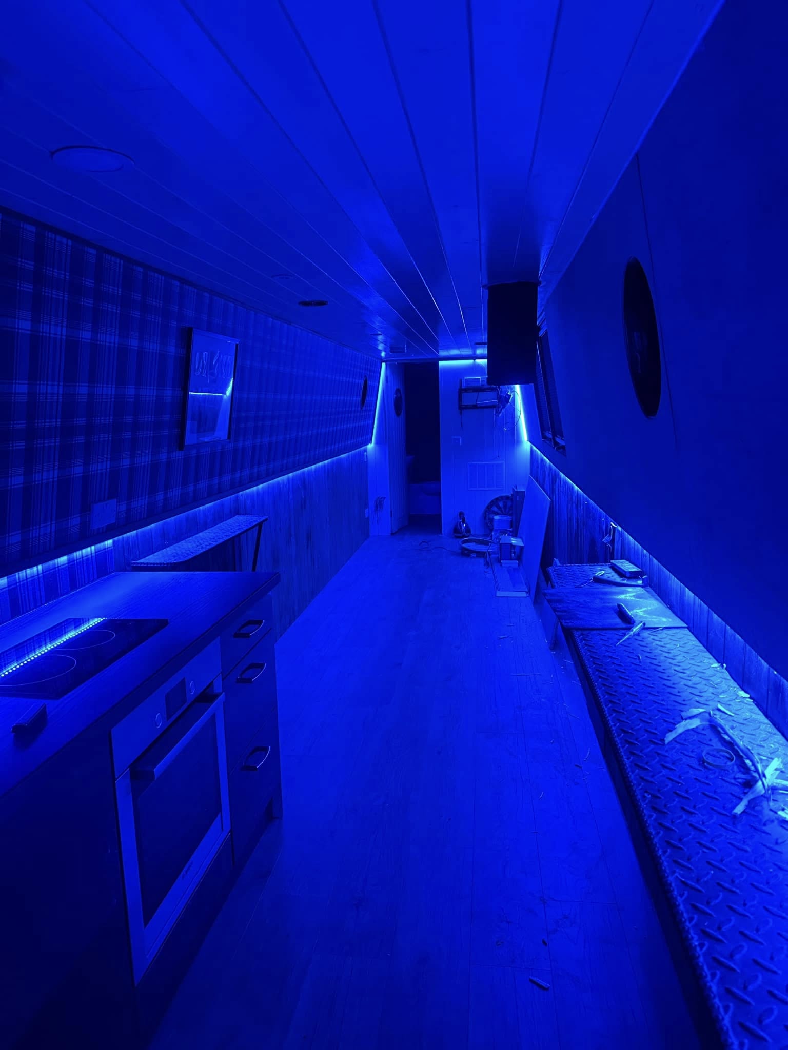 Blue LED strip lighting installed through a long kitchen interior