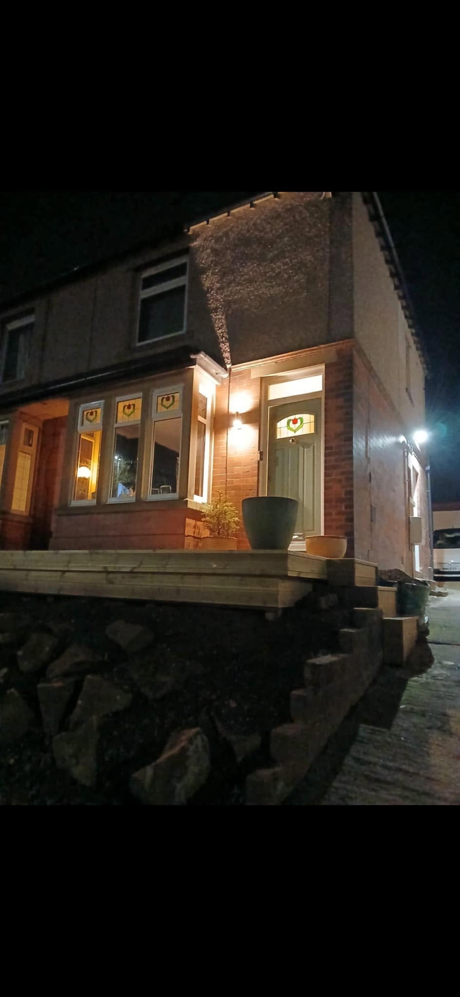 Exterior wall and security lighting illuminated at a house at night